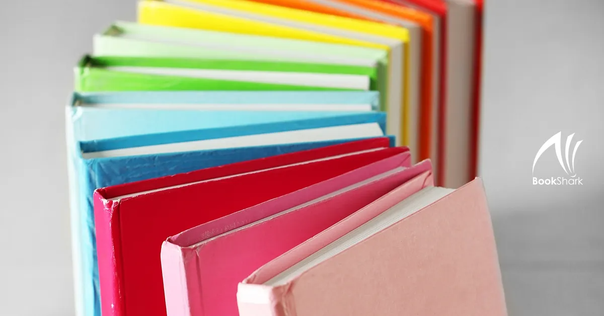 brightly covered books aligned in a curve, rainbow order