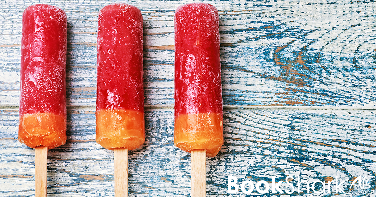 three red and orange popsicles sit on a blue and white distressed wood background