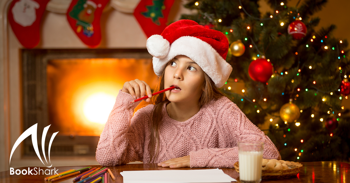 a girl in a red santa hat holds a pencil